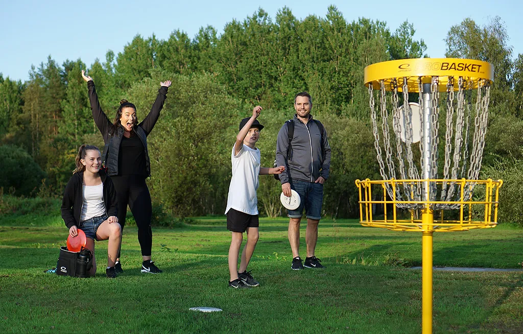 Familie spiller discgolf